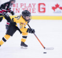 Jeune joueur de hockey patinant avec le palet