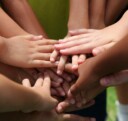 Children putting their hands together in a huddle
