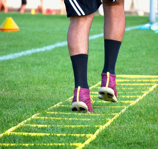 Athlete training his agility on a grass field