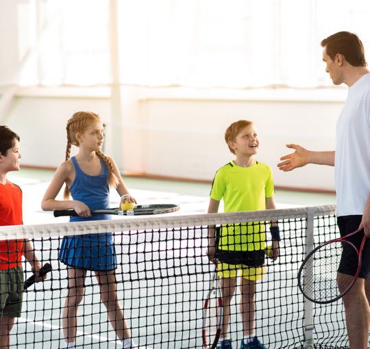Youth tennis coach with his athletes