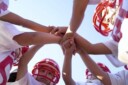 Young football players in a huddle with hands in the middle