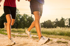 two people running on a dirt road 