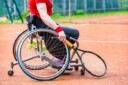 Joueur de tennis en fauteuil roulant sur un terrain en terre battue