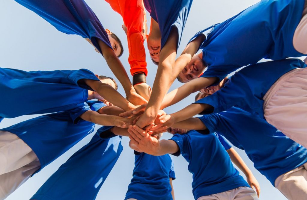 Children engaging in a huddle before their soccer game