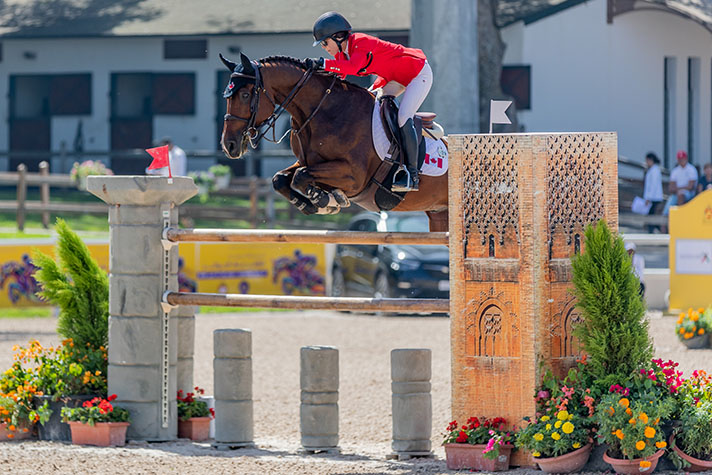 Equestrian Athlete jumping over obstacle