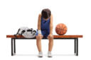 Sad little basketball player sitting on a bench