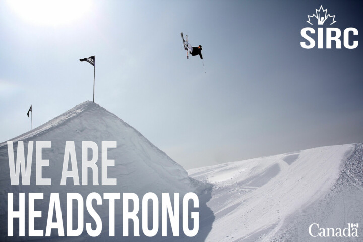 Freestyle skier in the air high above the hill. Text: We are headstrong. SIRC