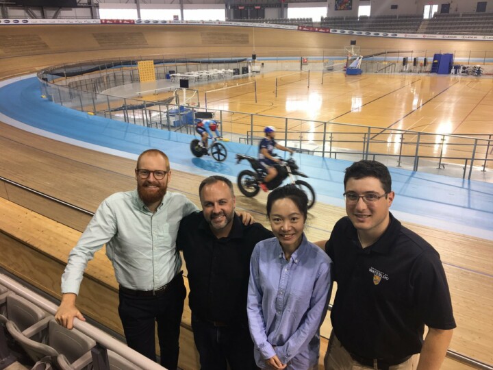 Four people at an indoor cycling facility