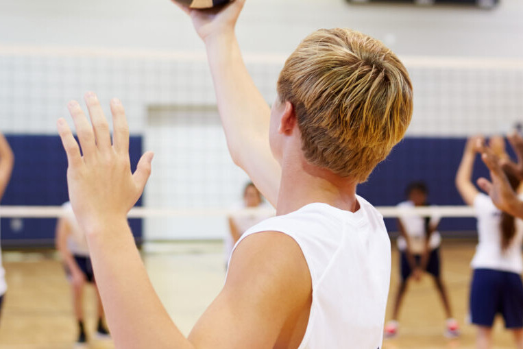 Male and female volleyball players playing a game