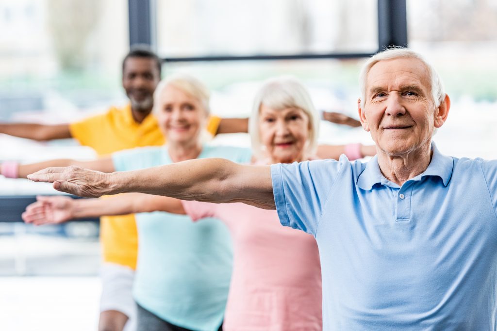 senior athletes synchronous doing exercise at gym