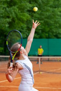 Women serving tennis ball