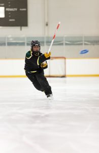 A young Ringette player throws the ring.