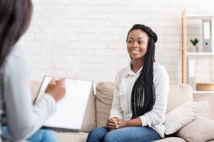 Women speaking with mental health consultant, happy.