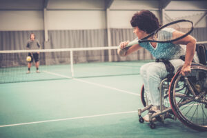 Female para athlete on wheelchair playing tennis on tennis court