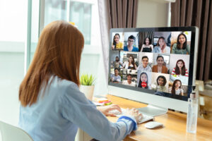 Young woman at computer doing an online video conference.