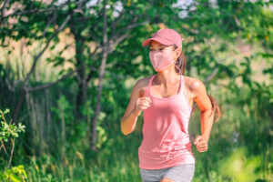 Woman running outside wearing a mask
