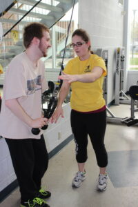 APEX participant and trainer using cable equipment in gym