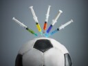 five syringes threaded in soccer ball.