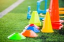 Practice equipment (cones and pylons) sitting on a green playing field