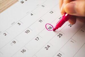 Female Hand with pen mark on calendar date