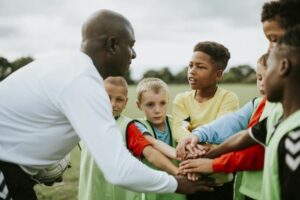 Junior football team stacking hands before a match 