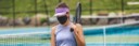 Tennis court reopen after covid-19 confinement. Woman athlete player wearing face mask during game playing oustide on outdoor courts banner panoramic.