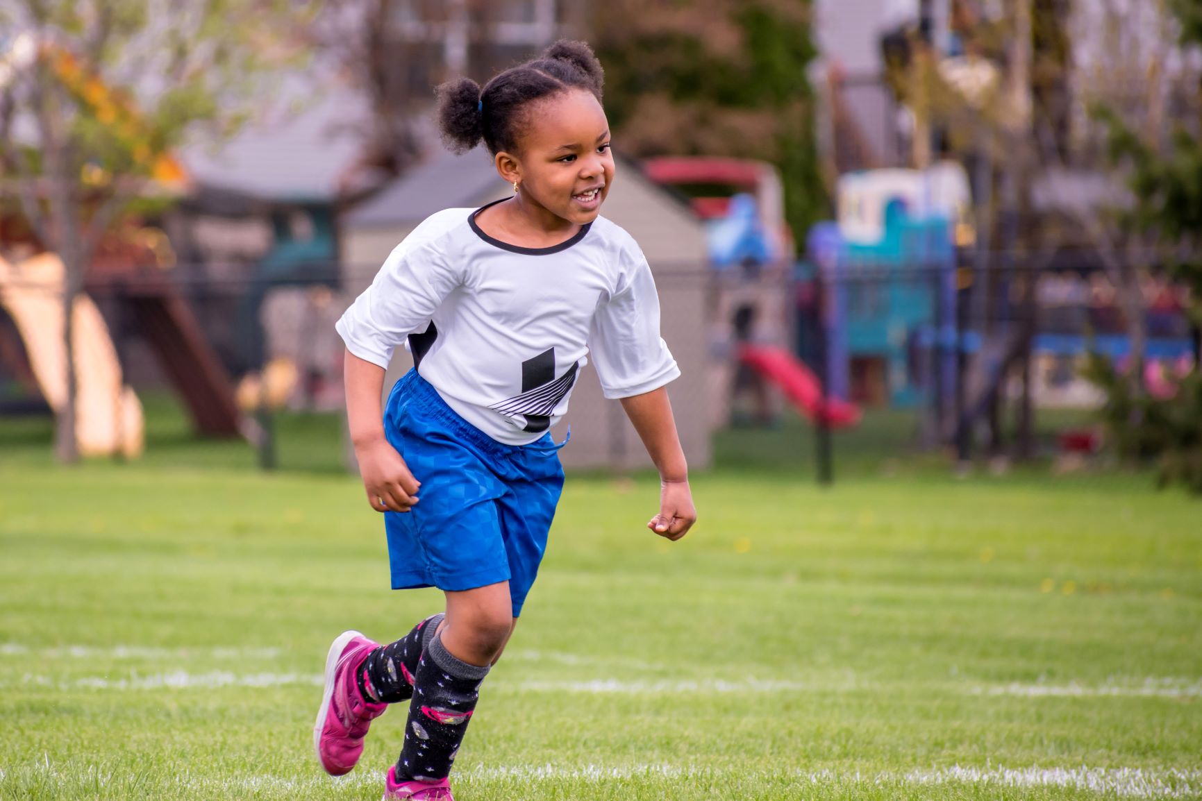 Youth female soccer player running on the field.