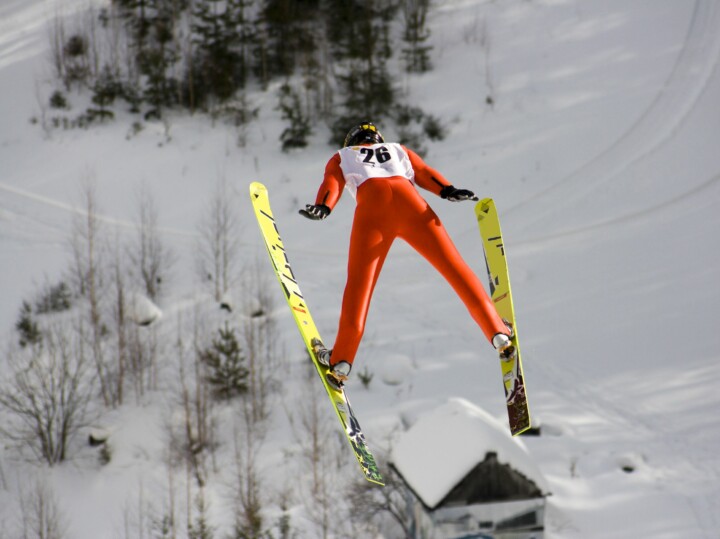 Competitive ski jumper flying through the air after leaving the ramp