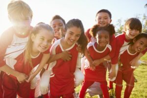 Children happy in their soccer uniforms.