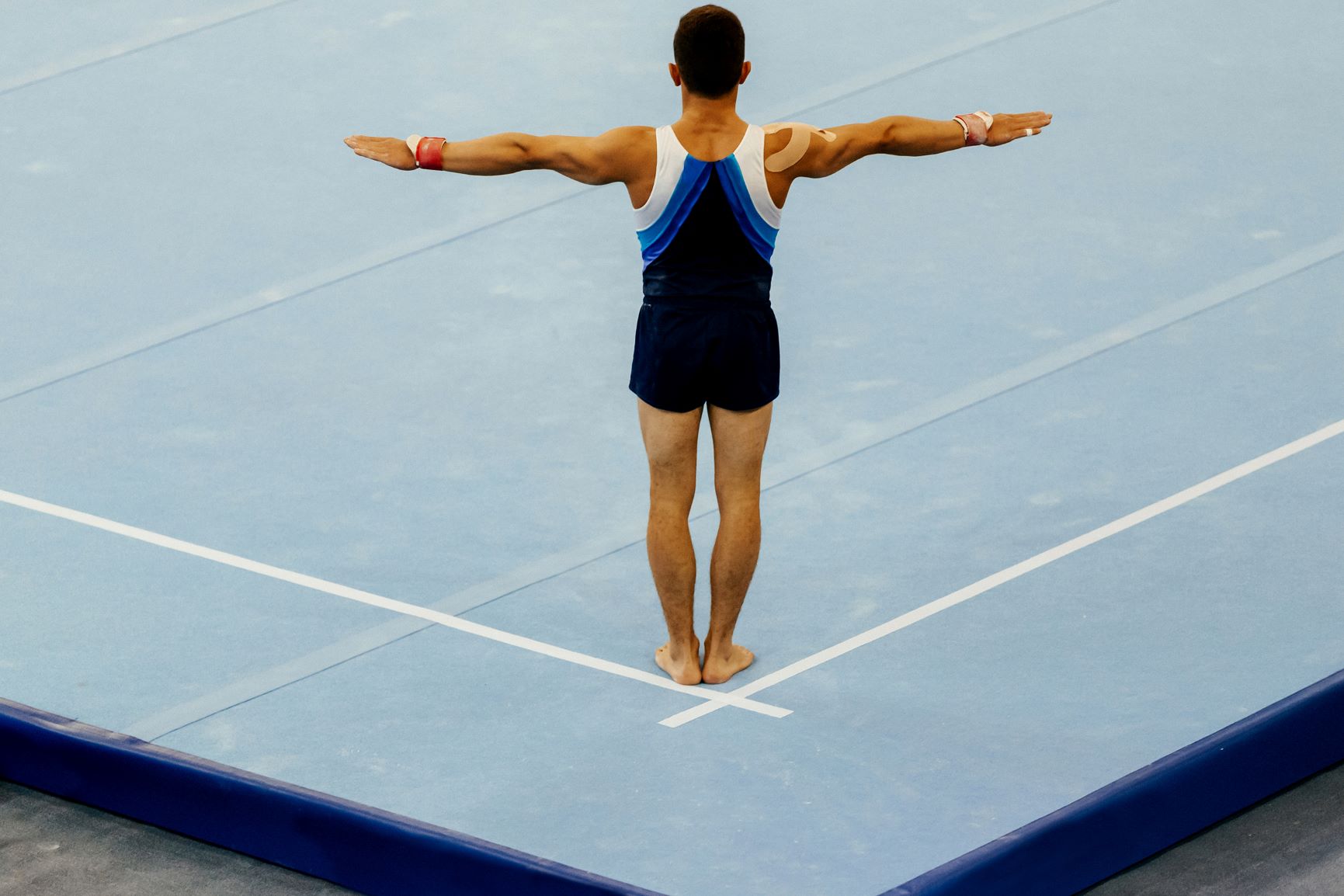 Male gymnast beginning floor routine.