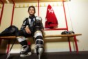 young male hockey player in dressing room 