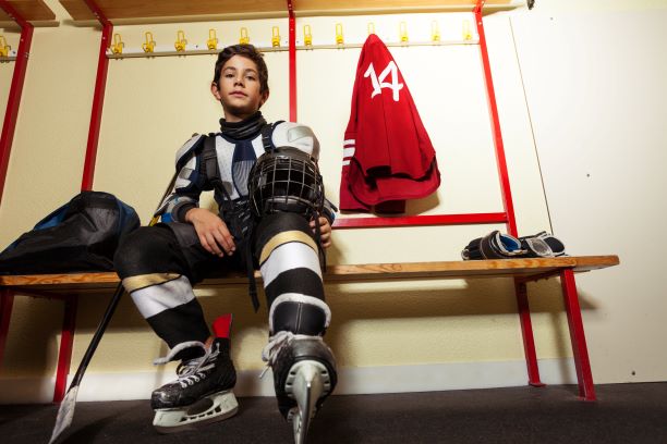 young male hockey player in dressing room