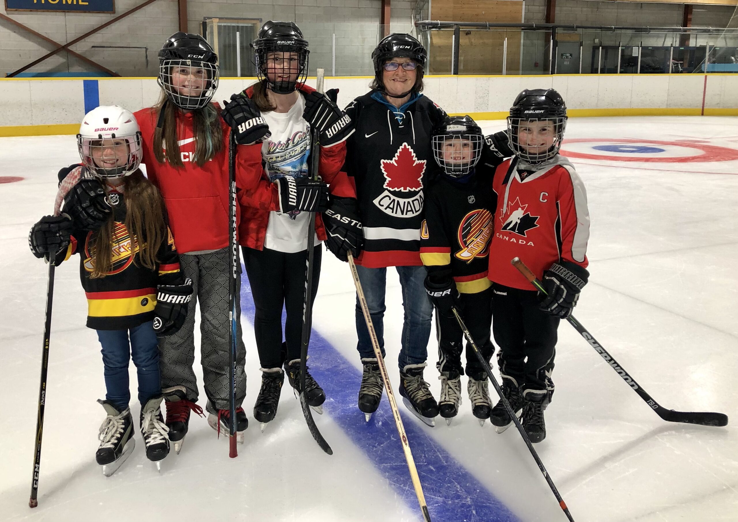 Mom Valerie on ice with young hockey players.