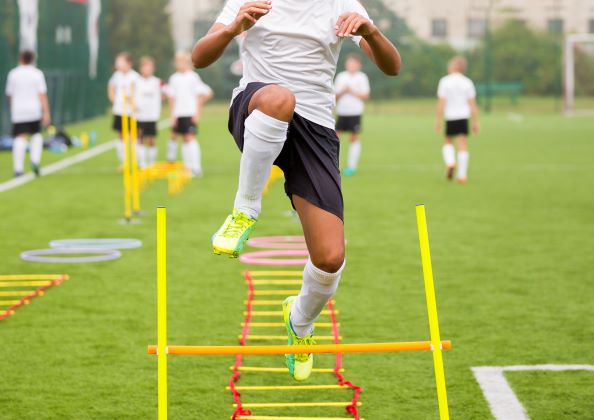 Youth soccer playing doing drills.