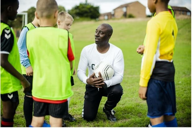 Youth soccer players in coach's huddle