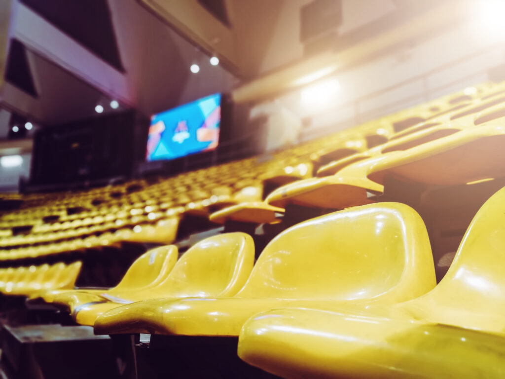 Hundreds of empty yellow seats in a stadium that has been shut off to spectators during the coronavirus pandemic.