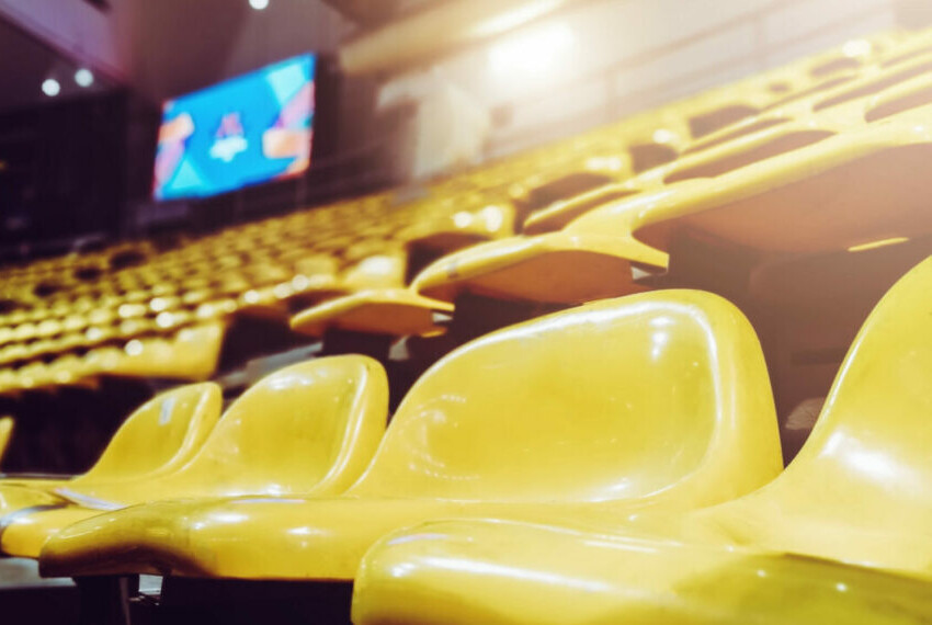 Hundreds of empty yellow seats in a stadium that has been shut off to spectators during the coronavirus pandemic.