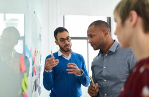 Portrait of a young businessman in a diverse team of creative millennial coworkers in a startup brainstorming strategies