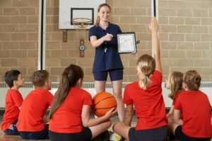 Coach Giving Team Talk To Elementary School Basketball Team