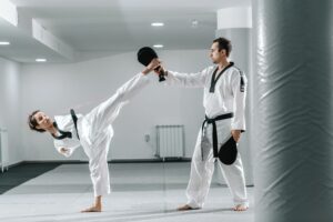 Young women with a disability practicing taekwondo with an instructor.