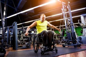 Man using a wheelchair working out in a gym. 