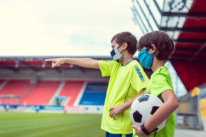 deux garçons portant des masques sur un terrain de football 