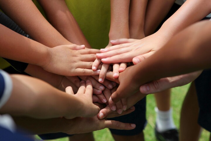 group of young people's hands in the centre of group ready to cheer