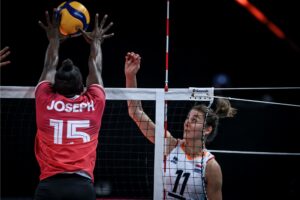 femme empêchant le volley-ball de passer par-dessus le filet.