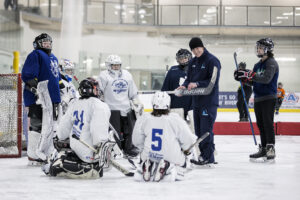 Youth hockey goalies being taught by a coach