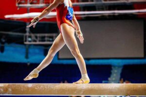 Female gymnast on balance beam.