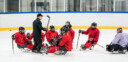 Coach talking to sledge hockey team