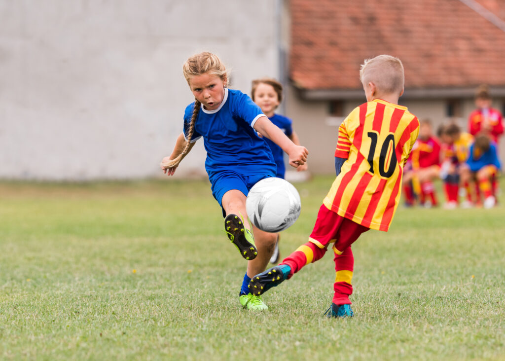 une fille jouant dans une équipe de football de garçons