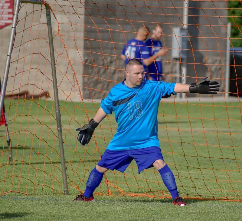 Teenage soccer goalie covering his net