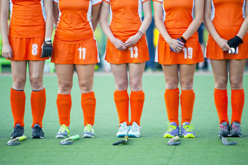 Women's field hockey team standing in a line